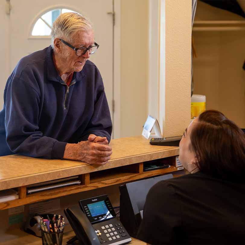 Patient obtaining periodontal insurance and financing information at the front desk of Willamette Valley Periodontics