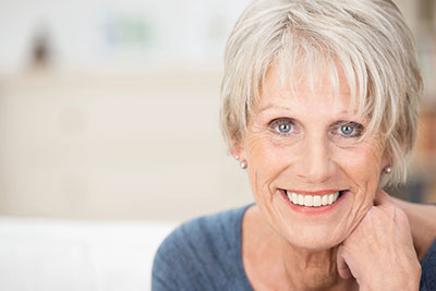 woman smiling after getting periodontal care at Willamette Valley Periodontics