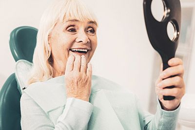 woman loving her smile after visiting Willamette Valley Periodontics