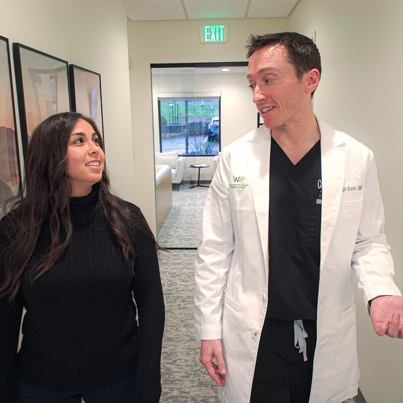 Dr. Colin Graser of Willamette Valley Periodontics walking down the hall with a patient.
